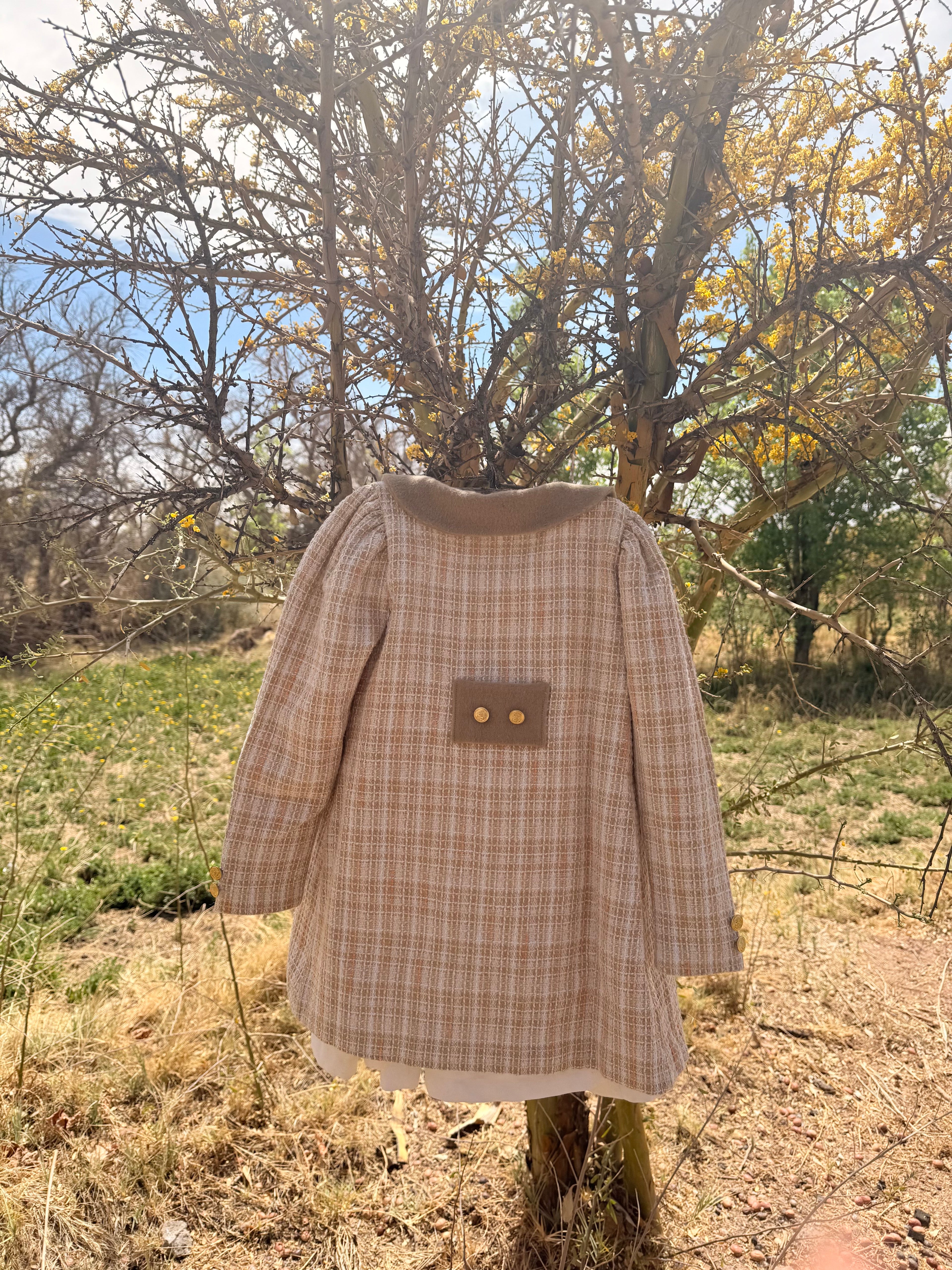 Abrigo de media estación estilo inglés Riso di Luna, en tweed con mangas fruncidas, botones dorados y cuello en baby alpaca. Bordado interior a mano y forro en algodón pima.
