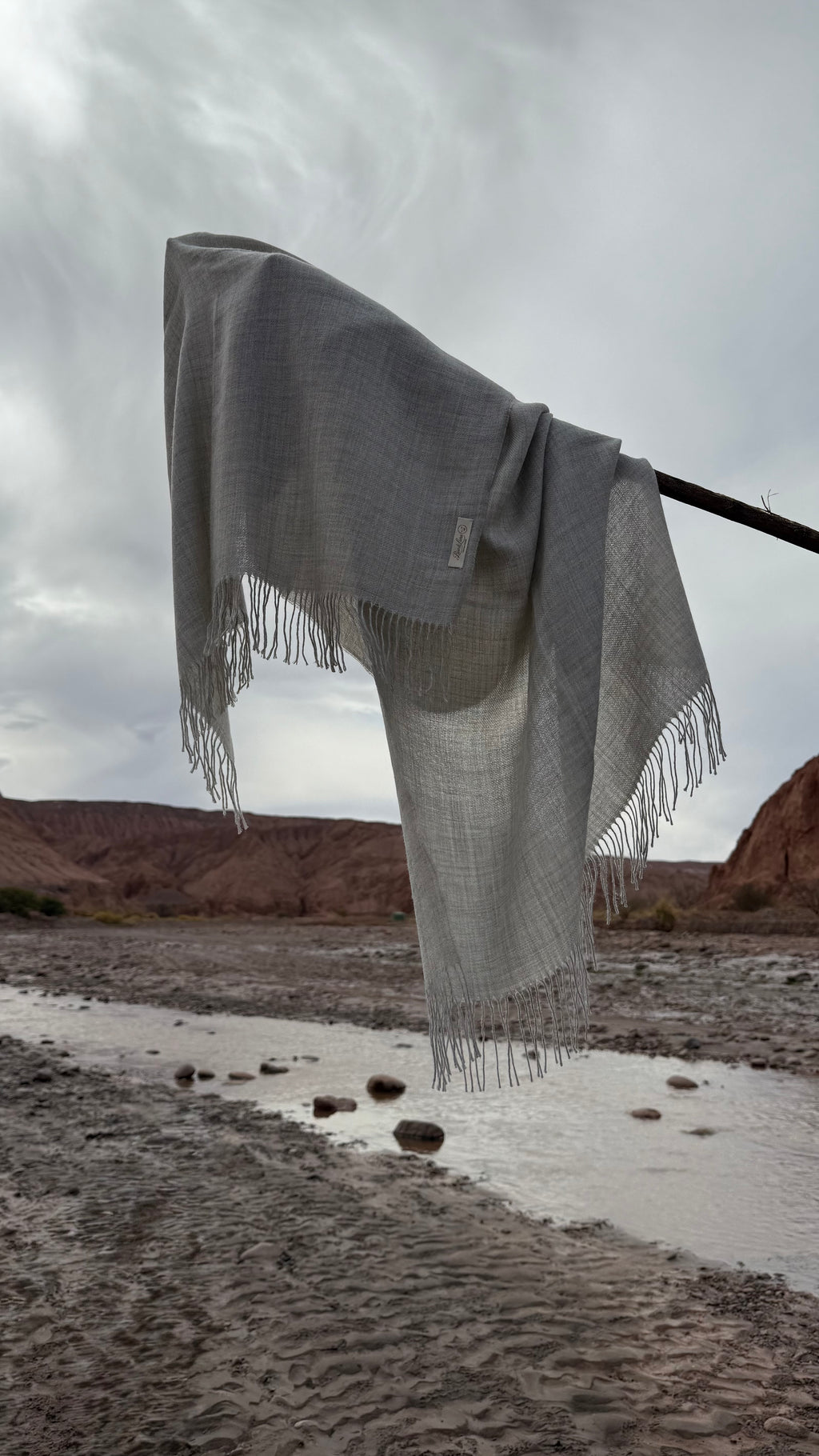 Estola Riso di Luna Niebla en baby alpaca eco gris claro inspirada en rocas sedimentarias del desierto.