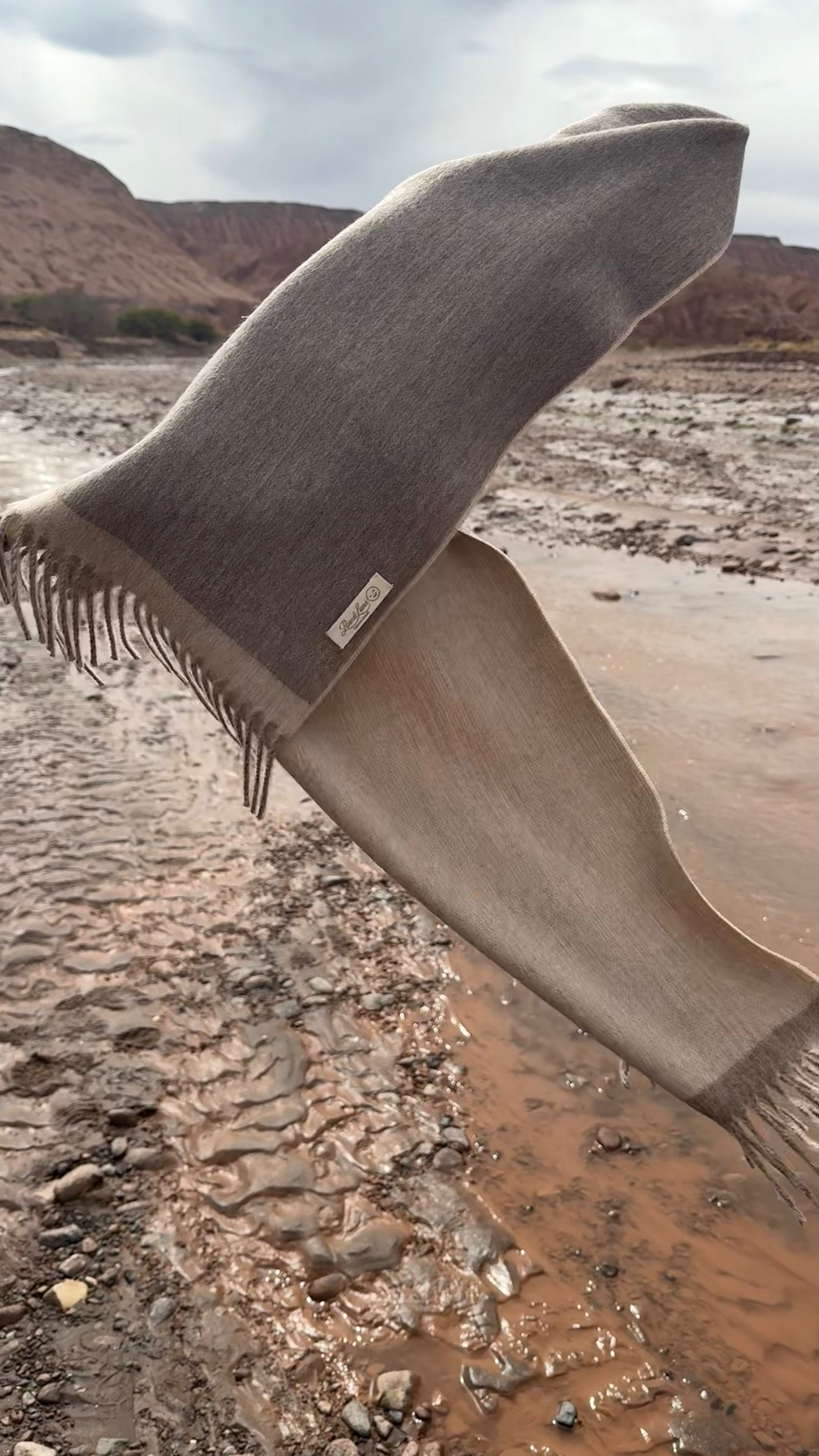 Bufanda “Dunas Doradas” Riso di Luna en tonos beige y canela, inspirada en la luz y arena dorada del desierto de Atacama. 100 % baby alpaca eco sin tintes y con procesos sostenibles.