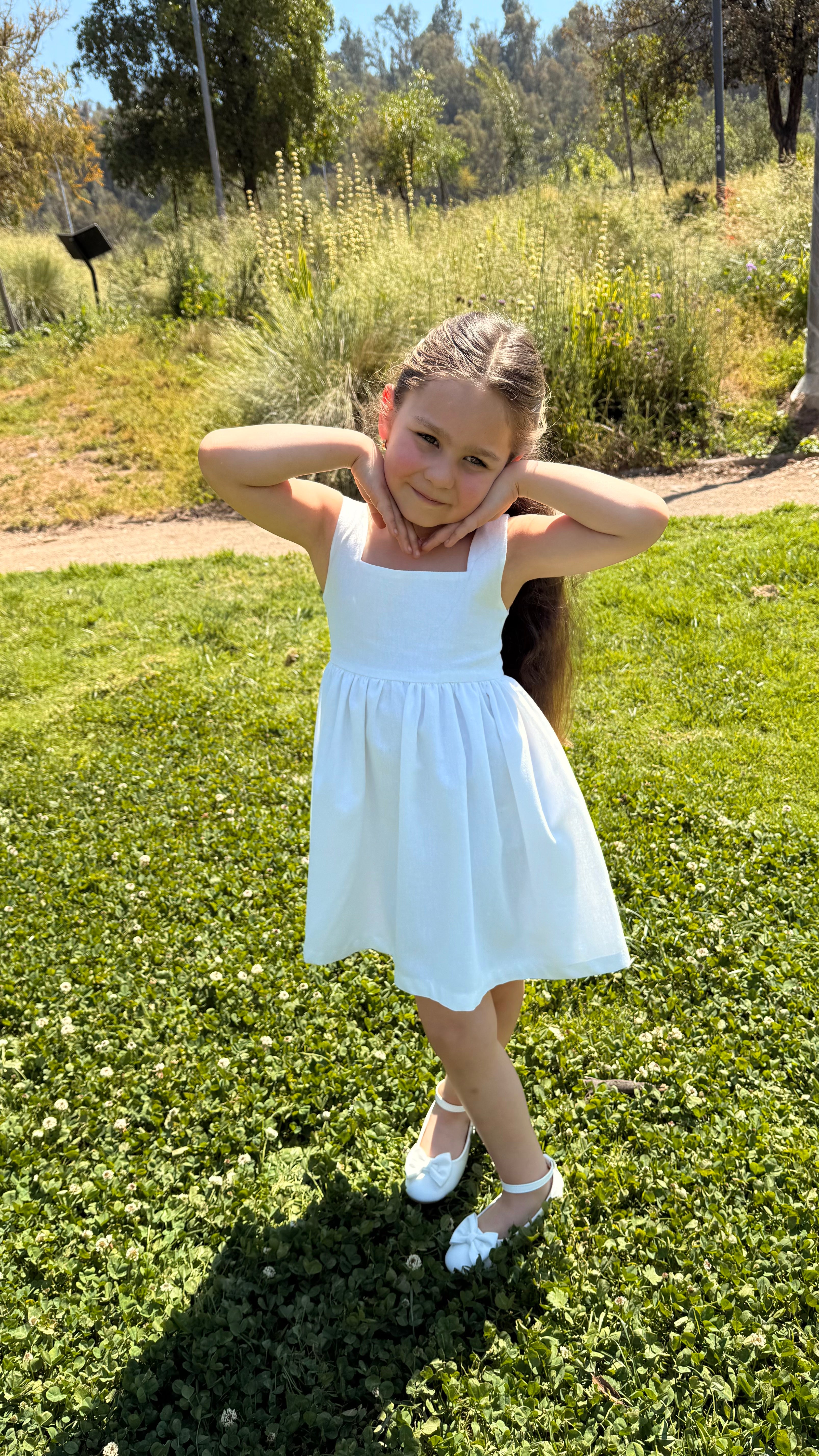 Vestido infantil en lino blanco con aire mediterráneo y espalda con smocking artesanal. Forro en algodón pima hipoalergénico. Diseño  sostenible Riso di Luna.