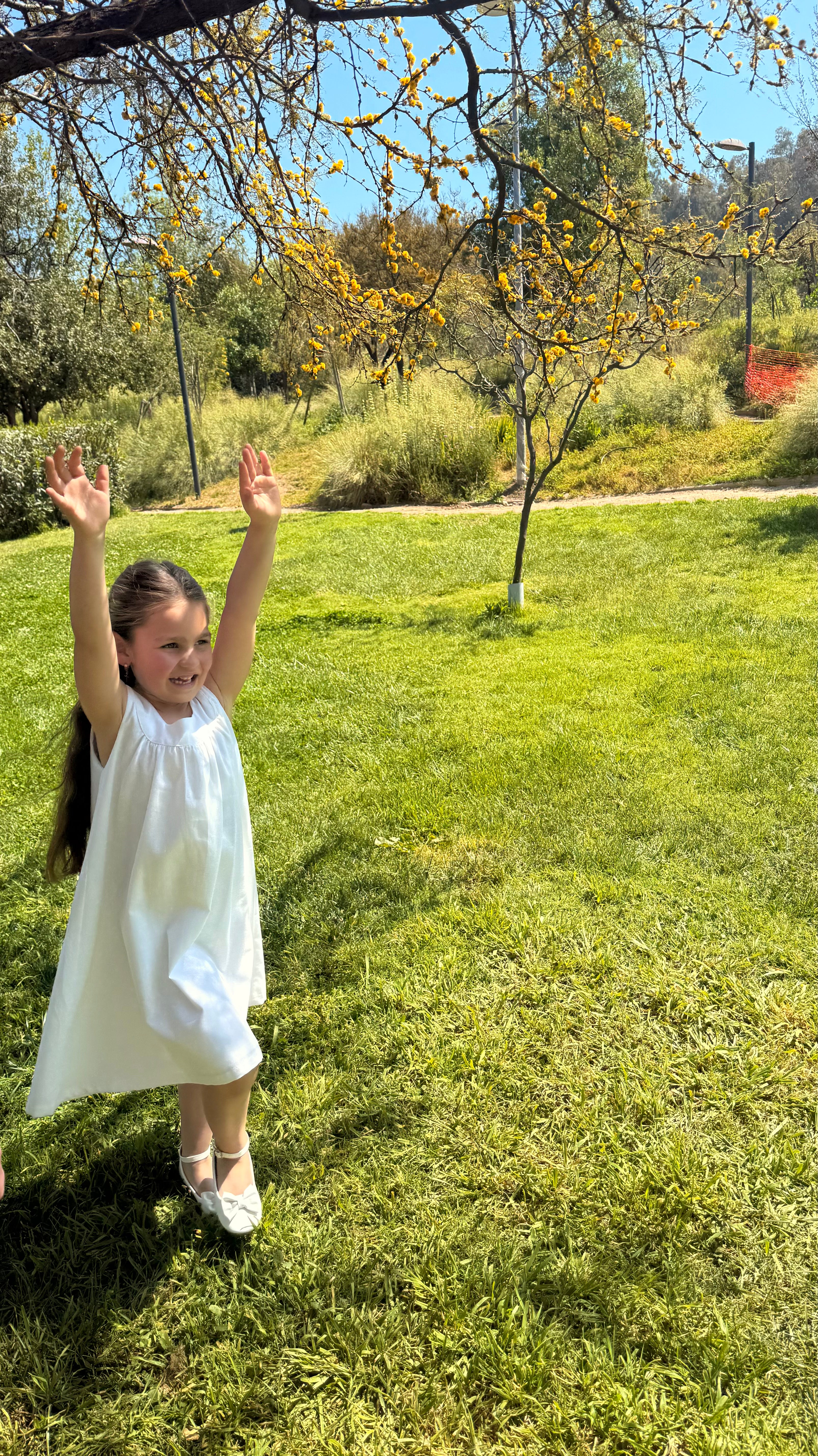 Vestido infantil en lino blanco con aire mediterráneo y smocking artesanal. Forro en algodón pima hipoalergénico. Lavar a mano. Diseño de lujo sostenible Riso di Luna.