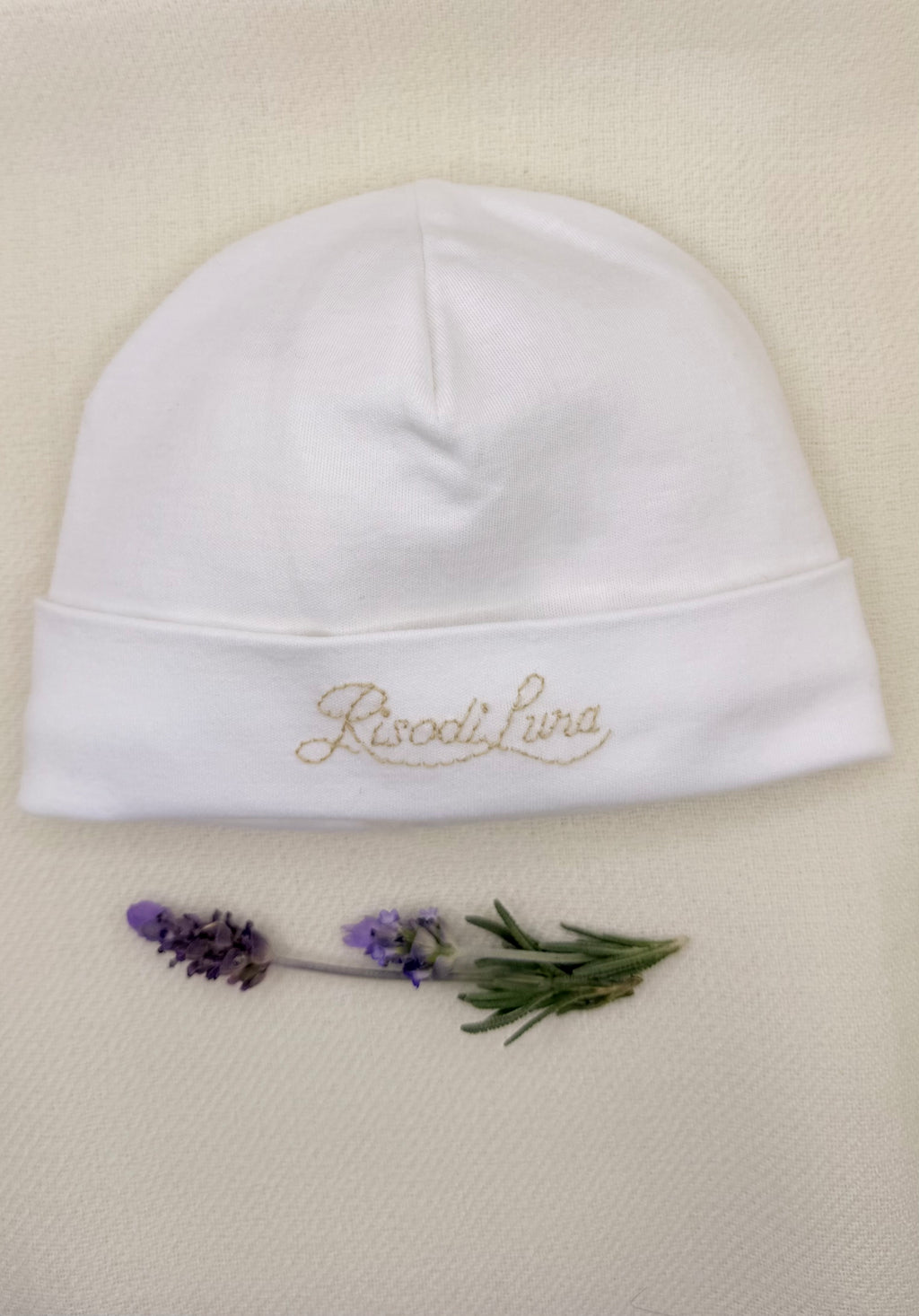 Gorro Raggio di Sole de Riso di Luna, hecho en 100% algodón pima blanco con bordado a mano. Suave, hipoalergénico y artesanal, ideal para la piel sensible del bebé.