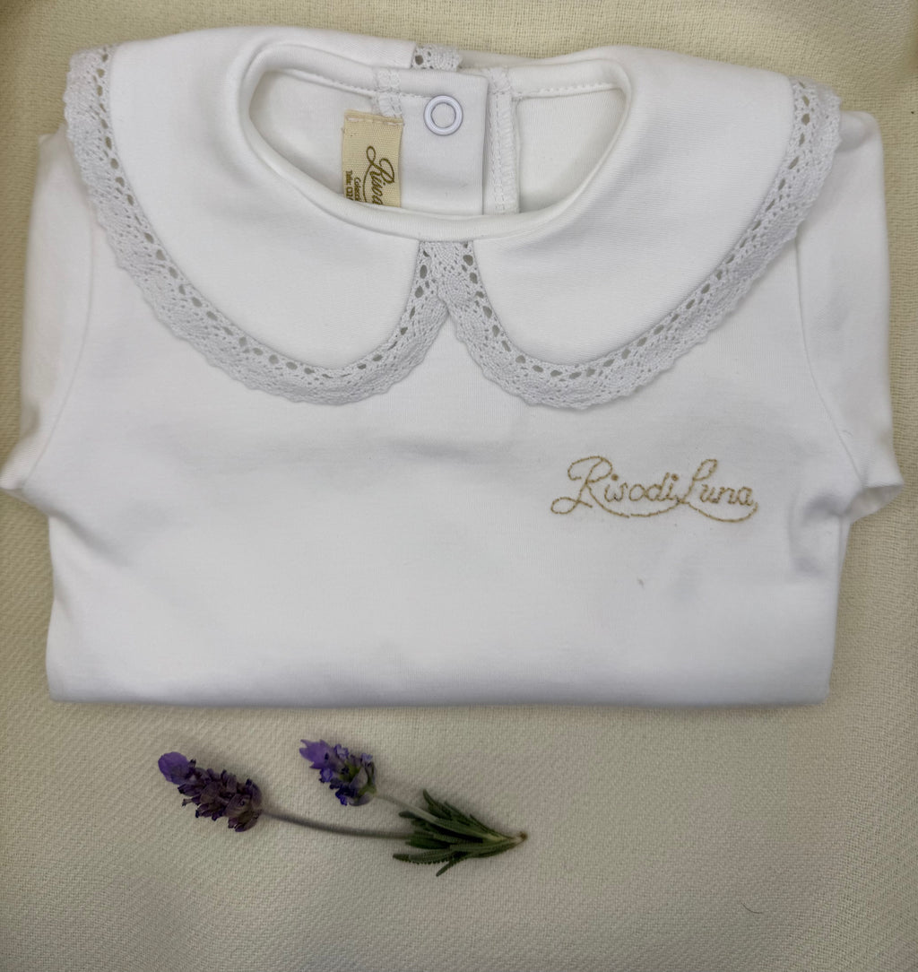 Body infantil Luna Chiara en algodón pima hipoalergénico, con cuello bordado a mano en hilo de algodón. Hecho a mano en Chile por Riso di Luna, marca de lujo artesanal sostenible.