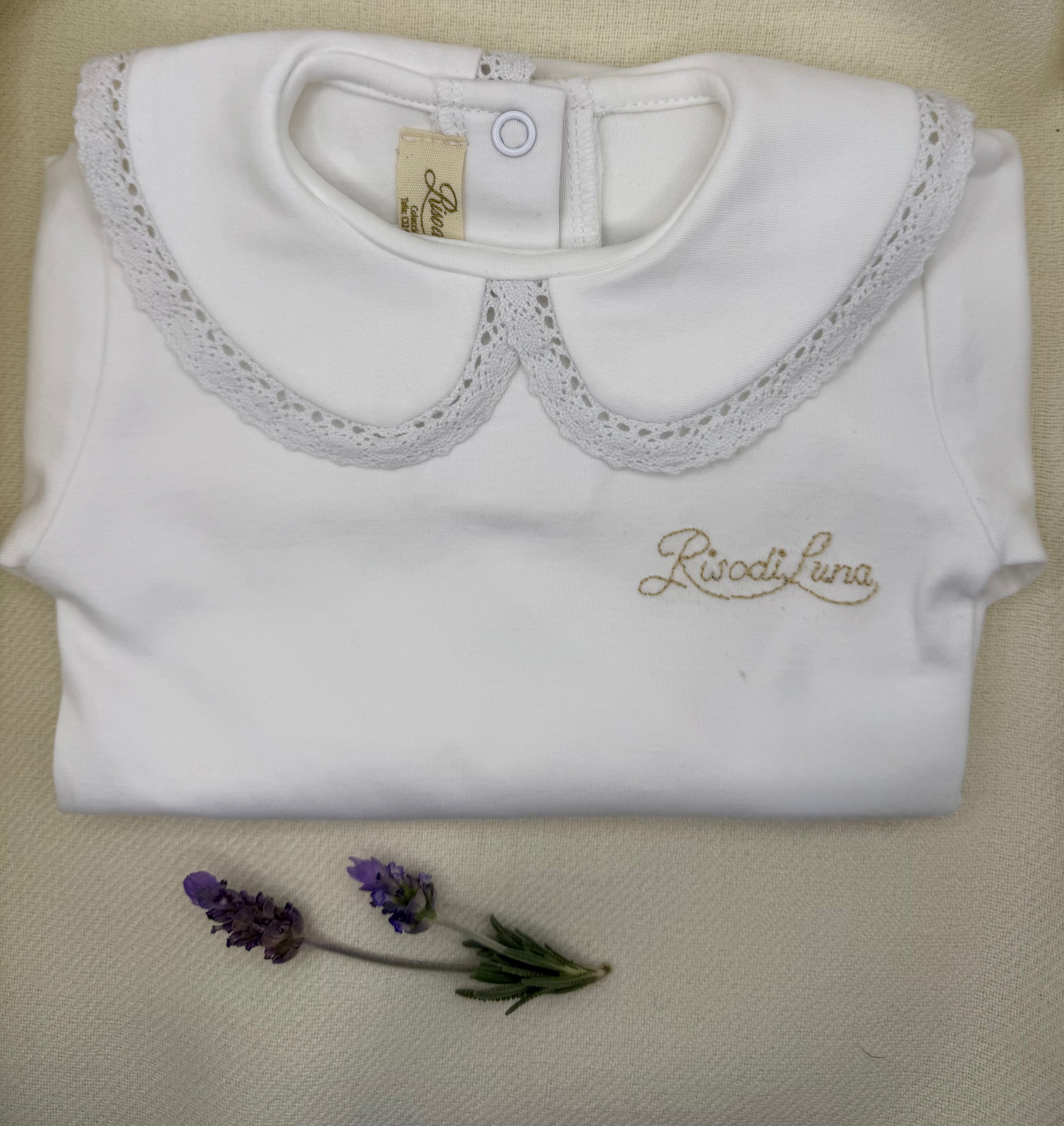 Body infantil Luna Chiara en algodón pima hipoalergénico, con cuello bordado a mano en hilo de algodón. Hecho a mano en Chile por Riso di Luna, marca de lujo artesanal sostenible.