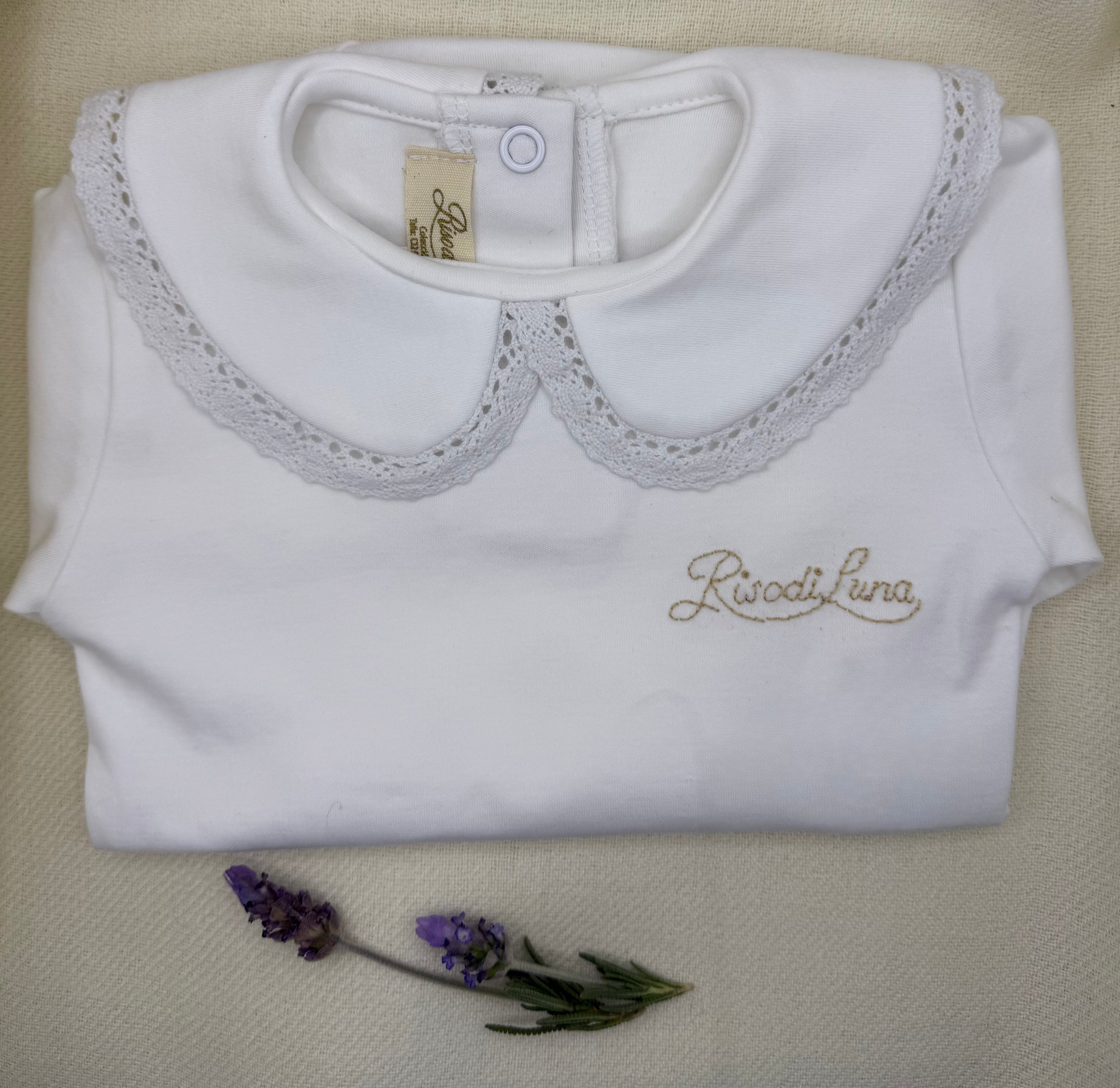 Body infantil Luna Chiara en algodón pima hipoalergénico, con cuello bordado a mano en hilo de algodón. Hecho a mano en Chile por Riso di Luna, marca de lujo artesanal sostenible.